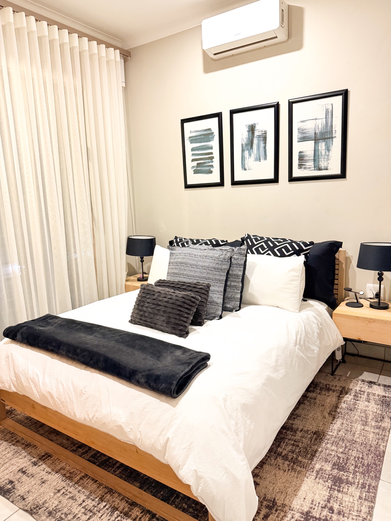 Second bedroom with monochrome art and queen bed