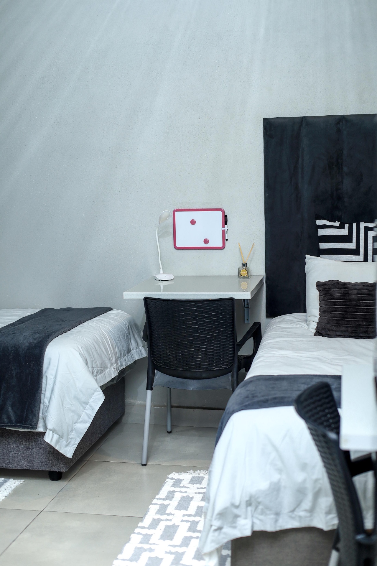 Twin beds and a shared study desk in a Mziyako student room